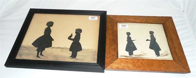 Lot 1087 - A Silhouette Cutout Double Child Portrait, circa 1840, depicting a young girl standing before a...