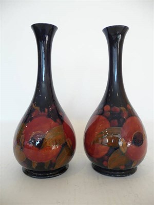 Lot 1126 - A Pair of William Moorcroft "Pomegranate" Vases, on a dark blue ground, painted green...