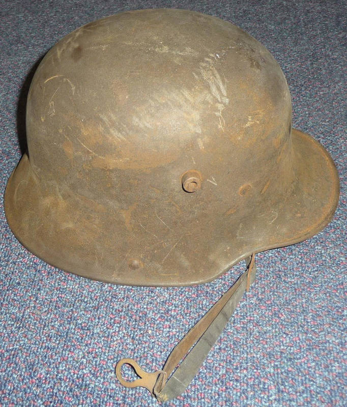 Lot 79 - A First World War German Helmet, with raised cylindrical stud air vents, folded rim, leather...