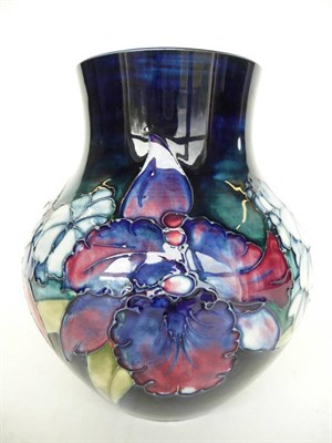 Lot 1129 - A Walter Moorcroft "Orchid and Spring Flowers" Baluster Vase, on a blue ground, impressed...