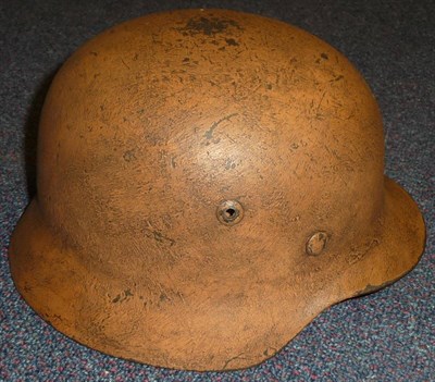 Lot 91 - A German M40 Steel Helmet, with tan camouflage finish, with folded rim, the interior stamped...