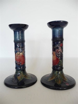 Lot 1132 - A Pair of William John Moorcroft "Finches" Candlesticks, designed by Sally Tuffin, on a blue...