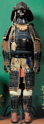 Lot 131 - A Japanese Gosuko (Suit of Armour), of black lacquered metal and green floral silk brocade,...