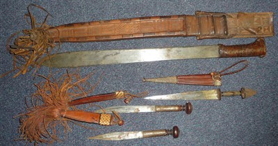 Lot 216 - A North African Sword, with single edge broad steel blade, leather bound hilt and tooled...