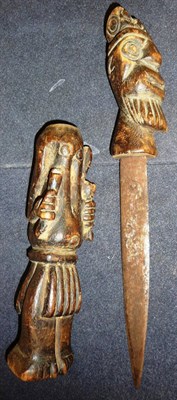 Lot 230 - A West African Dagger, with double edge steel blade, the wood hilt and scabbard carved as the...