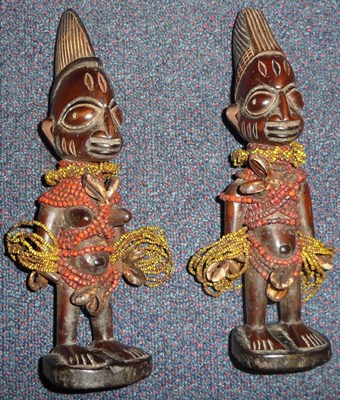 Lot 271 - A Pair of Yoruba Ibeji Twin Figures, male and female, each decorated with strands of yellow and red