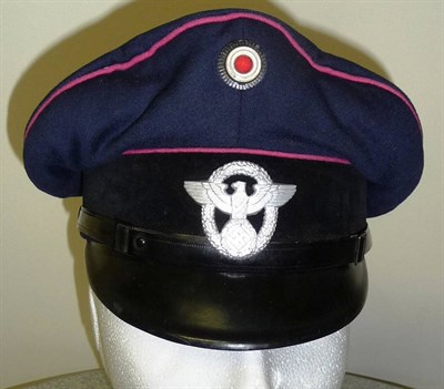 Lot 101 - A German Third Reich Fire Official NCO's Peaked Cap, in dark blue cloth with pink piping, black...