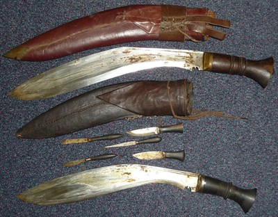 Lot 130 - A Nepalese Kukri, with notched curved steel blade, ebony grip and leather scabbard set with...