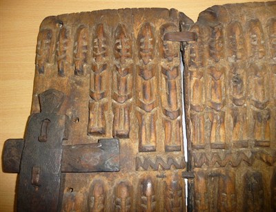 Lot 187 - A Dogon Wood Granary Door, in two panels, carved with two rows of fourteen seated figures, with...