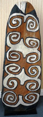 Lot 193 - An Asmat, Papua New Guinea Wooden War Shield, of tall arched form, carved and painted in ochre,...