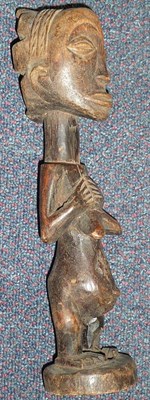 Lot 197 - A Luba, Congo Wood Figure of a Woman, standing with her hands resting above her pendulous...