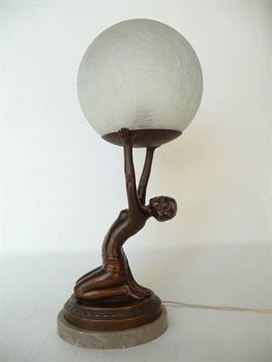 Lot 1183 - An Art Deco Patinated Spelter Figural Table Lamp, modelled as a kneeling nude holding a crackle...