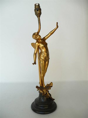 Lot 1185 - An Art Nouveau Gilt Spelter Figural Lamp, modelled as a semi-nude fairy tip toeing on leaves,...