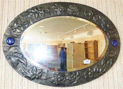 Lot 1192 - An Arts and Crafts Embossed Pewter Mirror, decorated with stylised vines and grapes, set with...