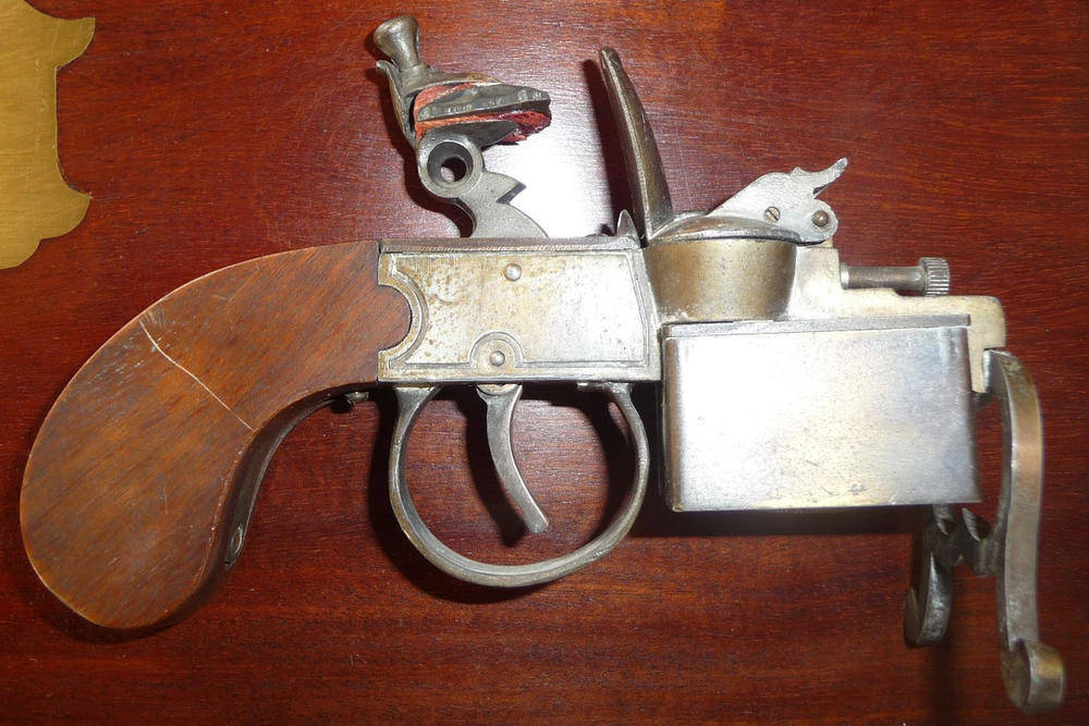 Lot 77 - A Ronson's "Tinder Pistol" Table Cigarette Lighter, with walnut slab butt.
