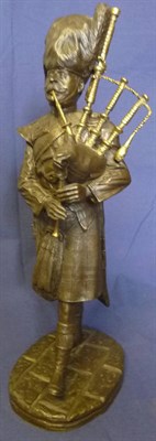 Lot 125 - A Bronzed Resin Figure of a Scottish Piper, wearing busby, tunic and kilt, playing the bagpipes, on