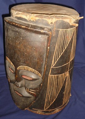 Lot 334 - An African Ebonised Wood Mask Drum, of cylindrical form, one side carved in high relief with a...