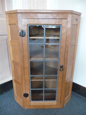 Lot 1235 - A Robert "Mouseman" Thompson Glazed Panelled Oak Hanging Corner Cupboard, the leaded glazed...