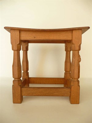 Lot 1241 - A Robert "Mouseman" Thompson Oak Dish Top Stool, with solid seat, on four octagonal legs joined...