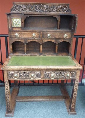 Lot 1249 - An Arts and Crafts Oak Writing Desk, possibly French, the upper section with a carved upstand above