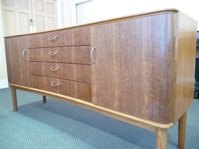 Lot 1261 - A 1960's Gordon Russell Teak and Indian Laurel Sideboard, with shaped top above two cupboard...