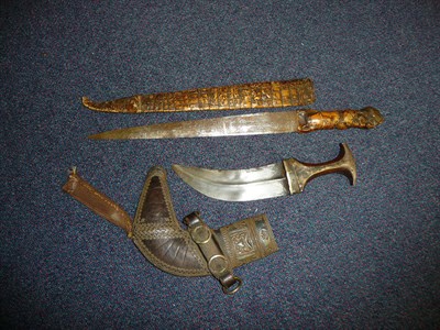 Lot 330 - An Arab Jambiya, the curved steel blade with medial ridge, the wood grip and leather scabbard...