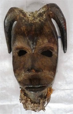 Lot 342 - A Dan Mask, the oval face with domed forehead and two down-curved horns, pierced eyes,...