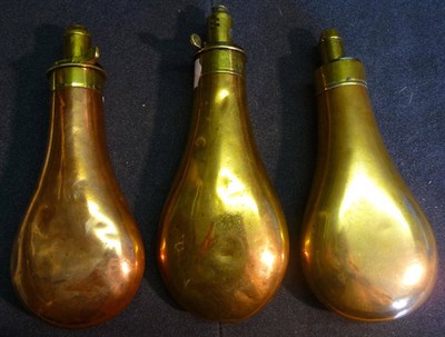 Lot 375 - Three Copper Powder Flasks, of plain pear shape, each with brass charger, one by James Dixon &...