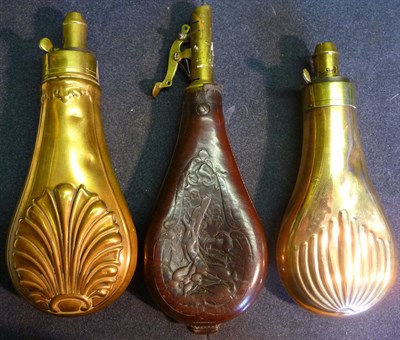 Lot 376 - Two Copper Powder Flasks, with brass chargers, one embossed with a shell, the other embossed...