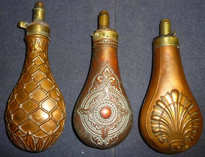 Lot 394 - Three Copper Powder Flasks, with embossed decoration of a shell, strapwork and beadwork...