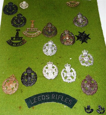 Lot 70 - A Display Card of Nineteen Leeds Rifles Cap Badges and Shoulder Titles, including officer's...