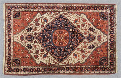 Lot 1332 - Saroukh Rug  West Persia  The ivory field with angular stylised plants around an indigo pole...