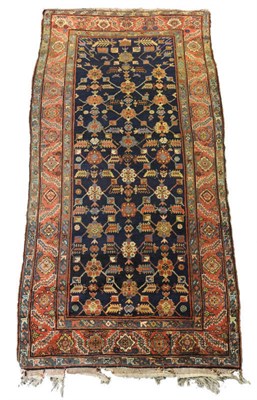 Lot 1368 - North West Persia Rug The indigo diamond lattice field  with polychrome flowerheads enclosed by...