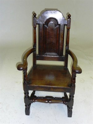 Lot 1401 - A Joined Oak Armchair, the shaped top rail above a fielded panel back, the spindle and block...