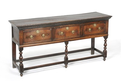 Lot 1413 - An Early 18th Century Oak Low Dresser, the rectangular top above three conforming deep drawers,...