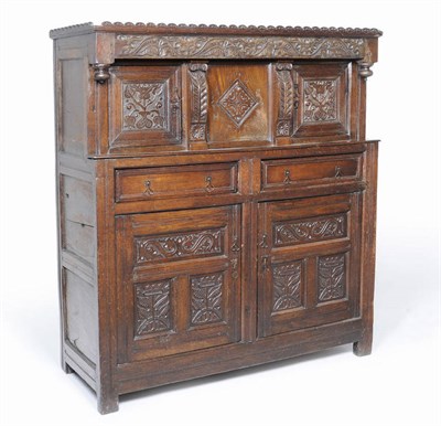 Lot 1415 - A Joined Oak Press Cupboard, the upper section with carved moulding above a heavily carved...