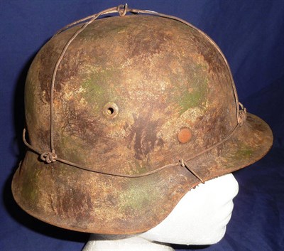 Lot 138 - A German Third Reich M42 Helmet,  with camouflage paint and attached with bailing wire, the...