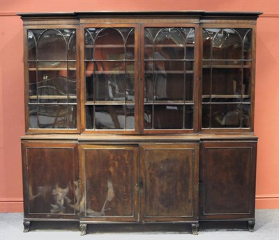 Lot 1448 - A Mahogany Breakfront Bookcase, the bold pediment above two astragal glazed doors enclosing...