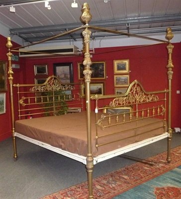 Lot 1465 - A Victorian Four-Poster Super King Size Bed, late 19th century, the pierced brass headboard...