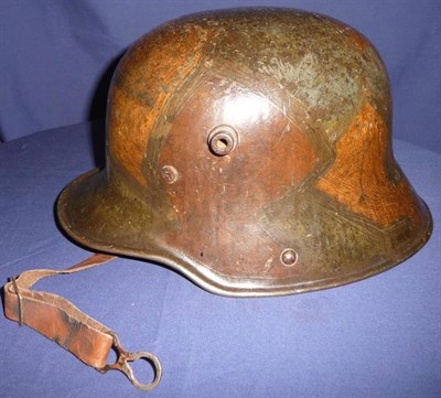 Lot 127 - A German M17 Army Helmet, in block camouflage paint, the interior left inner edge stamped OV,...