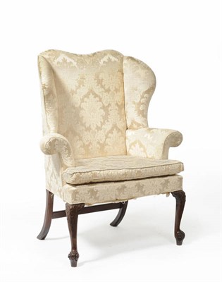 Lot 1483 - A Queen Anne Style Wing Armchair, upholstered in cream silk damask, the serpentine top rail between