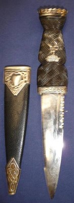 Lot 279 - A Scottish Skein Dhu, with scallop back steel blade, the ebony grip carved with stylised knot work