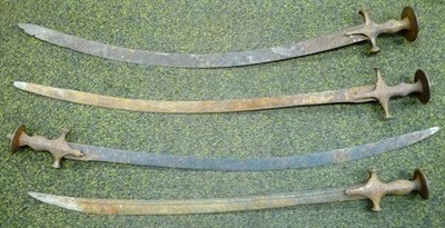 Lot 328 - Four 19th Century Indian Talwars, each with slightly curved steel blade, baluster grip and disc...