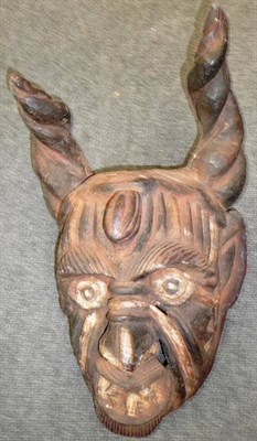 Lot 354 - A Mexican Carved Wood 'Day of the Dead' Mask, with long curling horns, bulging eyes below a...