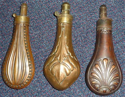 Lot 397 - Three Copper Powder Flasks, one embossed with overlapping leaves and with brass Patent charger with