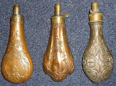 Lot 398 - Three Copper Powder Flasks: one embossed with a foliate cartouche with lobed base, the brass...