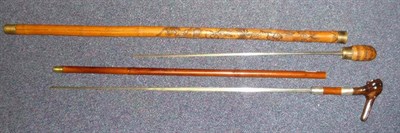 Lot 198 - A Bamboo Sword Stick, with 64cm T section steel blade, the wood grip carved with two human...