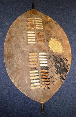 Lot 275A - A Zulu Hide Shield, of elliptical form, with a central laced band supporting the wood spine,...