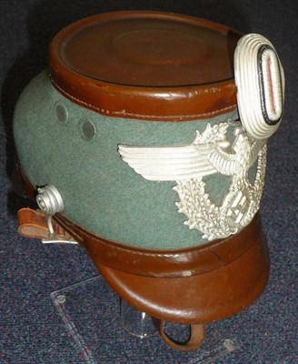 Lot 141 - A German Third Reich Police Shako Hat, with green wool body, flat brown hard leather top, front and