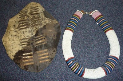 Lot 283 - A Zulu Beadwork Coiled Necklace (Umgingqo), the thickly coiled cotton body covered in bands of...